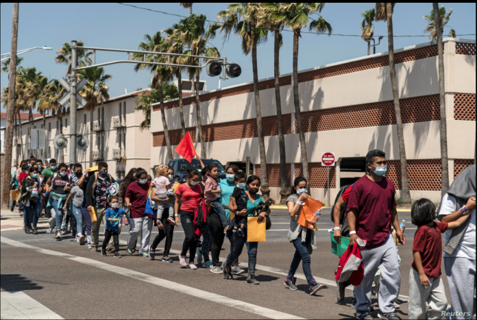 Familias de inmigrantes marchan hacia un albergue temporal en McAllen, Texas, EE. UU., el 8 de abril de 2021.