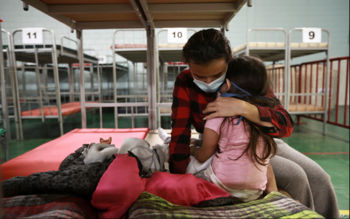 Ana María Moreno Portillo, de Guatemala, abraza a su hija tras ser deportadas de Estados Unidos, en el Complejo Deportivo Kiki Romero en Ciudad Juárez, México, el lunes 5 de abril de 2021.
