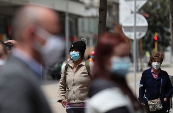 Personas usando mascarillas hacen fila mientras esperan que les hagan la prueba de COVID-19, en medio de un estricto bloqueo restablecido para ayudar a frenar la propagación del nuevo coronavirus, en Bogotá, el sábado 10 de abril de 2021.