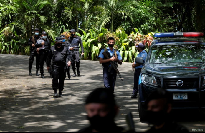 Policías nicaragüense se agrupan frente la casa de la precandidata presidencial Cristiana Chamorro, quien fue arrestada el 2 de junio de 2021 por acusaciones de lavado de dinero.