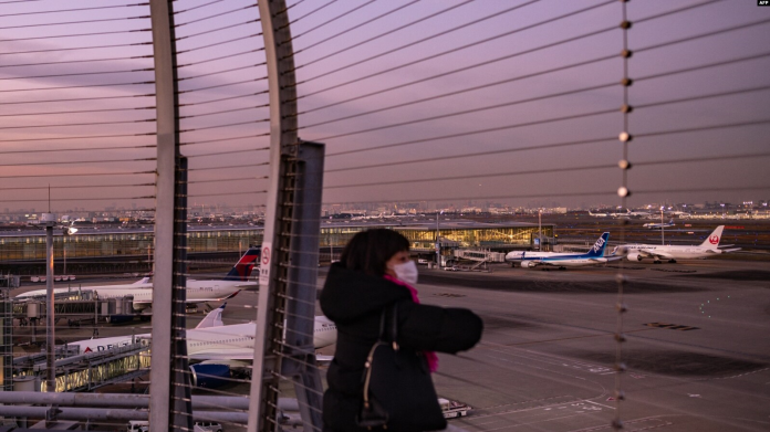 Una mujer mira desde la plataforma de observación del aeropuerto internacional Haneda de Tokio el 29 de noviembre de 2021.