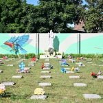 Personal de la Alcaldía de San Salvador coloca ofrendas florales de dolientes que visitan el área de fallecidos por COVID-19 del Cementerio La Bermeja. Foto: YSKL.