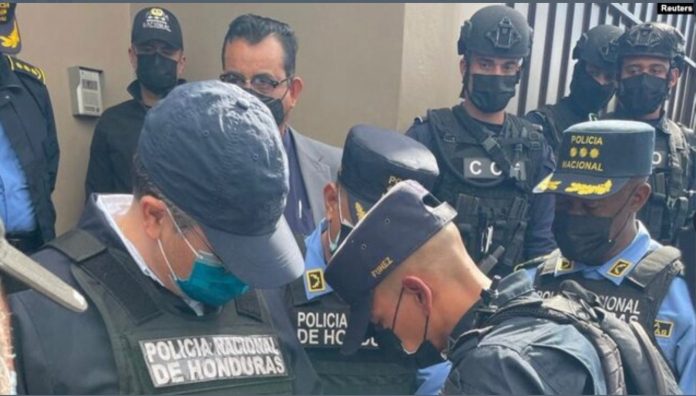 Oficiales de policía esposan al expresidente hondureño Juan Orlando Hernández después de ser detenido por miembros de la Policía Nacional de Honduras, en Tegucigalpa, Honduras, el 15 de febrero de 2022.