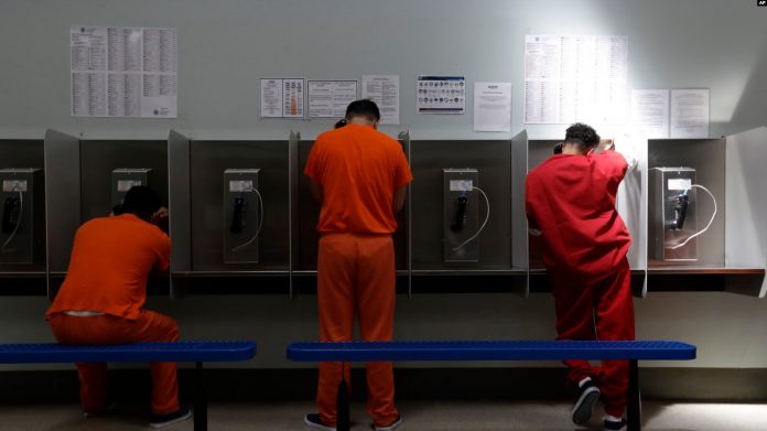 Unos detenidos hablan por teléfono en el centro de detención del Servicio de Control de Inmigración y Aduanas de Estados Unidos en Adelanto, California.