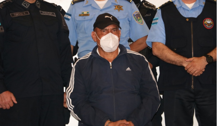 Oficiales de policía escoltan al exjefe de policía hondureño Juan Carlos 'El Tigre' Bonilla, quien está siendo extraditado a los Estados Unidos por cargos de narcotráfico, en Tegucigalpa, Honduras, el 10 de mayo de 2022.