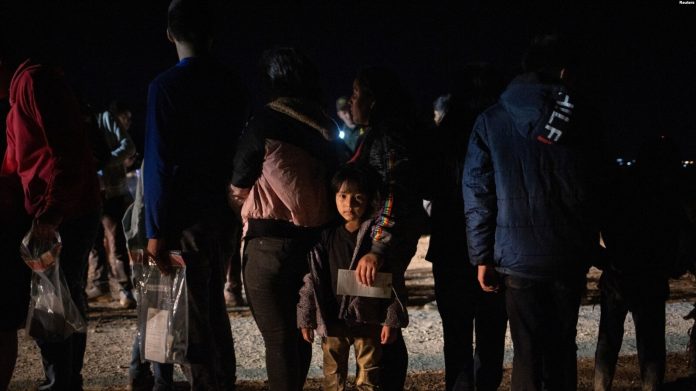 Una migrante hondureña de cinco años que busca asilo, es retenida por su madre mientras espera que los agentes de la patrulla fronteriza la registren después de cruzar el río Bravo hacia los Estados Unidos desde México en Roma, Texas, EEUU, el 5 de junio de 2022.