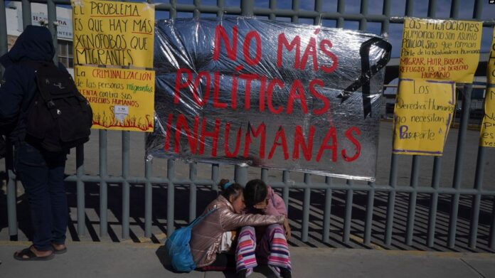 Dos hermanas venezolanas se consuelan en una acera de un centro de detención de migrantes donde docenas de migrantes que temían ser deportado perecieron en un incendio que mató a docenas de personas, en Ciudad Juárez, México, el martes 28 de marzo de 2023.