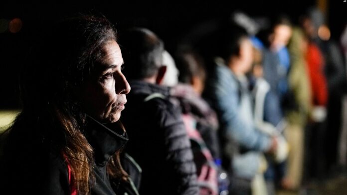 Una mujer de Cuba espera con otros migrantes para ser procesados para buscar asilo después de cruzar la frontera hacia Estados Unidos, el viernes 6 de enero de 2023, cerca de Yuma, Arizona. Imagen de Cortesía.