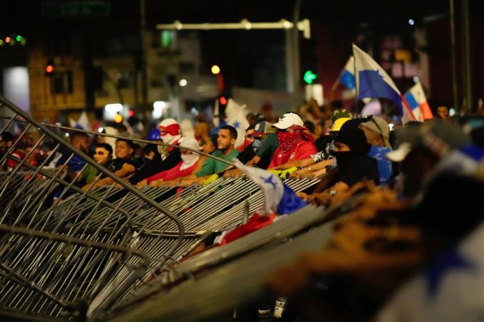 Manifestantes derriban una barricada policial durante una protesta contra un contrato minero recientemente aprobado entre el gobierno y la empresa minera canadiense First Quantum, en la ciudad de Panamá, el martes 31 de octubre de 2023. (Foto AP/Arnulfo Franco)
