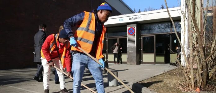 Solicitantes de asilo barren una plaza en Baden-Wurtemberg. Foto: Cortesía.