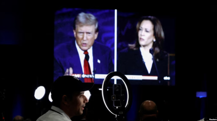 ARCHIVO - Miembros de los medios de comunicación usan una pantalla para ver el debate presidencial entre el expresidente republicano Donald Trump y la vicepresidenta demócrata Kamala Harris en Filadelfia, Pensilvania, EEUU, el 10 de septiembre de 2024.