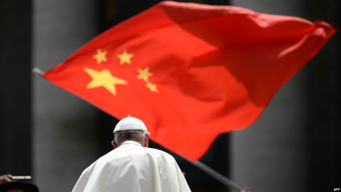 Un hombre agita la bandera de China mientras el papa Francisco se retira de una audiencia general en la Plaza de San Pedro en Ciudad del Vaticano, el 12 de junio de 2019.
