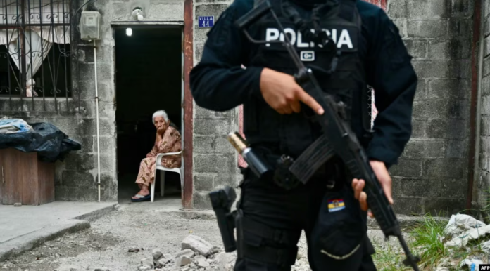 Una anciana mira a un policía ecuatoriano que participa en una operación conjunta de seguridad con las fuerzas armadas en Durán, Ecuador, el 24 de octubre de 2024.