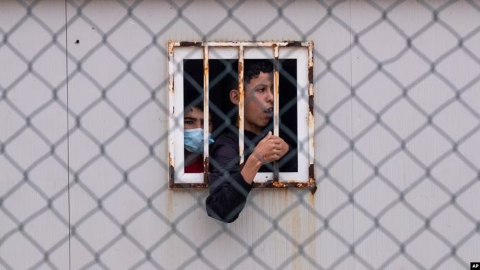 ARCHIVO - En esta fotografía de archivo del 20 de mayo de 2021, niños que cruzaron a España esperan dentro de un refugio temporal para menores no acompañados en el enclave de Ceuta, junto a la frontera de Marruecos y España. Foto: Cortesía.