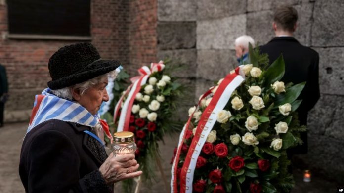 Un sobreviviente lleva una vela al Muro de la Muerte en el antiguo campo de concentración y exterminio nazi de Auschwitz-Birkenau, durante una ceremonia que conmemora el 80 aniversario de la liberación del campo, en Oswiecim, Polonia, el lunes 27 de enero de 2025. Foto: Cortesía.