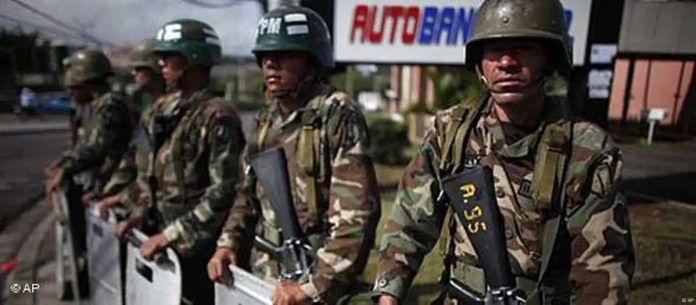 ARCHIVO-. Soldados montan guardia en una esquina cerca de la residencia presidencial en Tegucigalpa el miércoles 1 de julio de 2009, tras el derrocamiento del mandatario Manuel Zelaya.