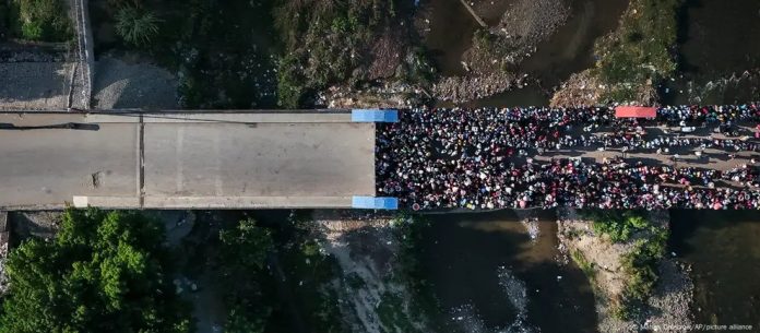 ARCHIVO.- Migrantes haitianos esperan para cruzar a República Dominicana, mientras la creciente violencia y la agitación política se apoderan de Haití.