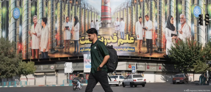 Un hombre camina junto a una valla que muestra centrifugadoras iraníes y científicos nucleares muertos en ataques israelíes, en Teherán, Irán (29.08.2025) Imagen de referencia. Foto: Cortesía.