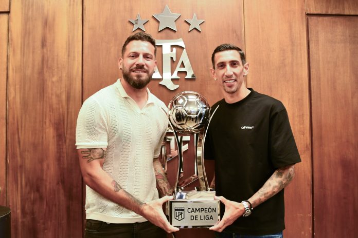 Di María y su compañero Jorge Broun junto al título de campeones. Foto cortesía: LigaAFA.